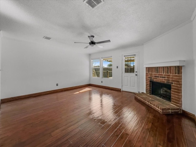 unfurnished living room with ceiling fan, a brick fireplace, a textured ceiling, and dark hardwood / wood-style flooring