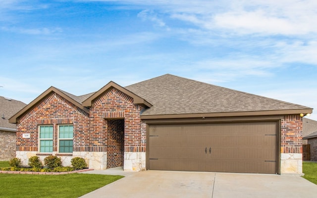 418 Rawhide Way, Princeton, TX 75407 - view of front of house featuring stone siding, roof with shingles, concrete driveway, a garage, and brick siding