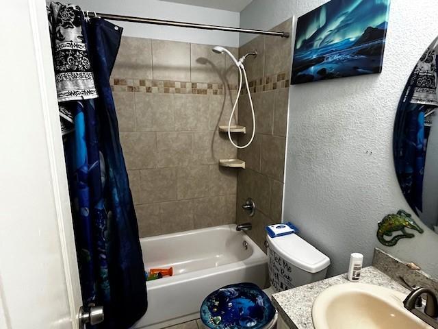 full bathroom featuring toilet, vanity, and shower / bath combination with curtain