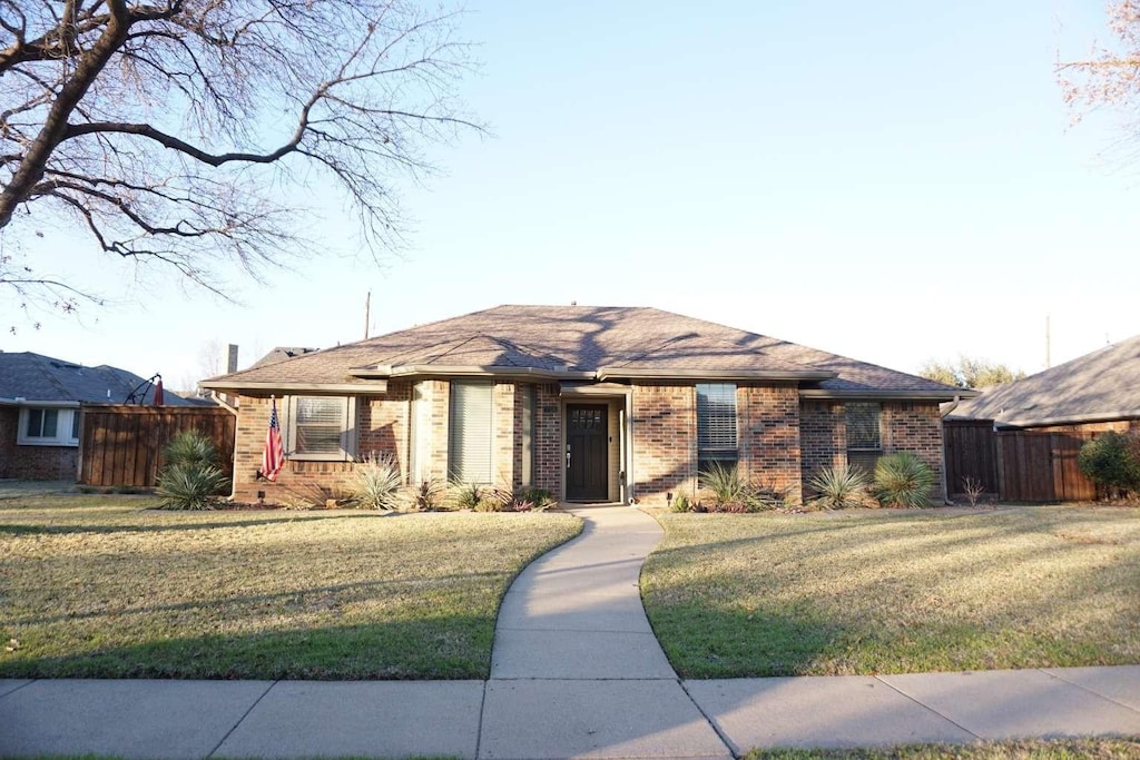 ranch-style home featuring a front lawn