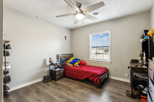 bedroom featuring ceiling fan, dark wood-type flooring, and a textured ceiling