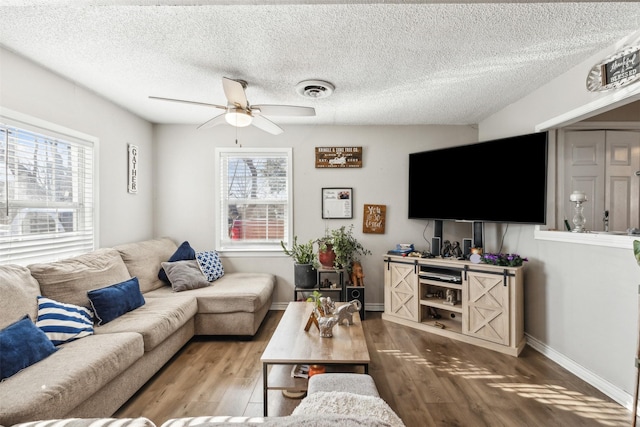 living room with a textured ceiling, ceiling fan, hardwood / wood-style floors, and plenty of natural light