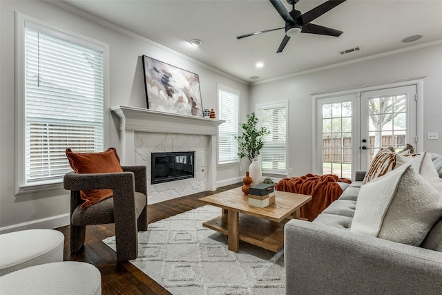 7800 Glenoaks Dr, Frisco, TX 75034 - living room featuring french doors, wood-type flooring, ornamental molding, and a tiled fireplace