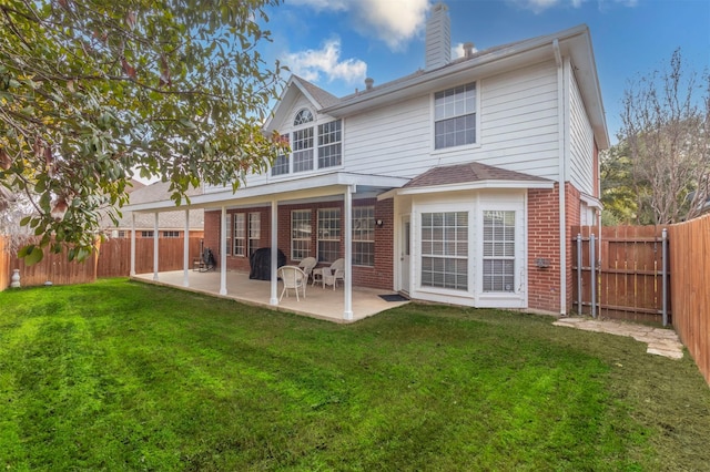 back of house with a patio area and a yard