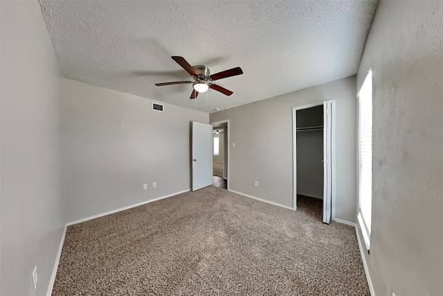 unfurnished bedroom with ceiling fan, a textured ceiling, a closet, and carpet floors