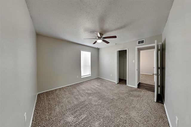 unfurnished bedroom featuring ceiling fan, a textured ceiling, a closet, and carpet flooring