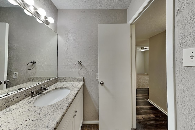 bathroom featuring a textured ceiling, ceiling fan, hardwood / wood-style flooring, and vanity