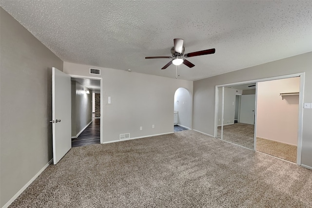 unfurnished bedroom with ceiling fan, a closet, carpet floors, and a textured ceiling