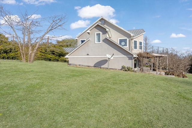 view of side of property featuring a balcony and a yard