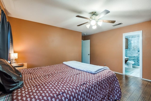 bedroom featuring dark wood-style flooring, visible vents, ensuite bathroom, a ceiling fan, and baseboards