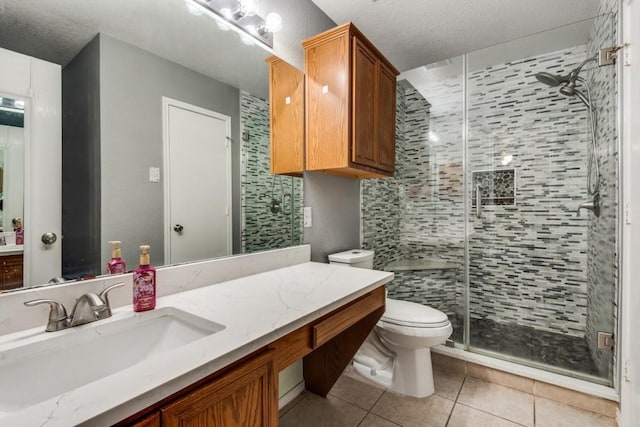 full bathroom featuring a textured ceiling, tile patterned flooring, toilet, vanity, and a shower stall