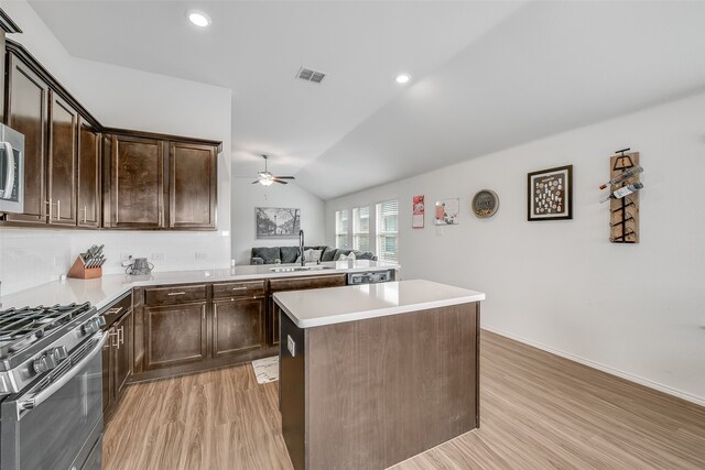 kitchen with sink, dark brown cabinetry, light hardwood / wood-style flooring, and vaulted ceiling