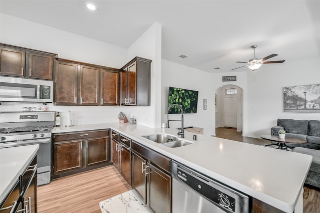 kitchen featuring light hardwood / wood-style flooring, sink, backsplash, lofted ceiling, and stainless steel appliances