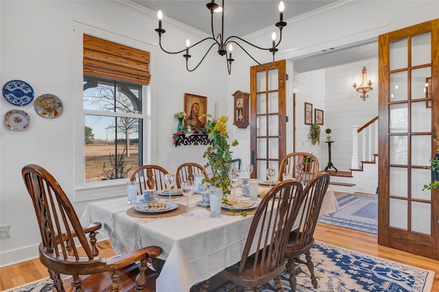 dining area featuring a chandelier, ornamental molding, and hardwood / wood-style floors