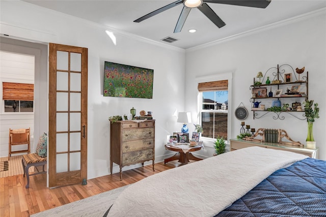 bedroom with ceiling fan, wood-type flooring, and crown molding