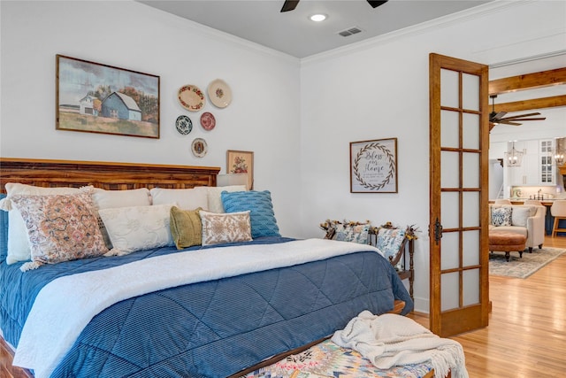 bedroom featuring ceiling fan, french doors, crown molding, and light hardwood / wood-style flooring