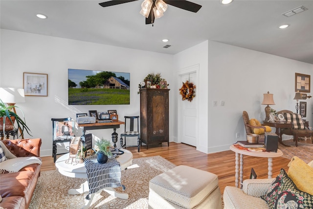 living room with ceiling fan and light hardwood / wood-style flooring