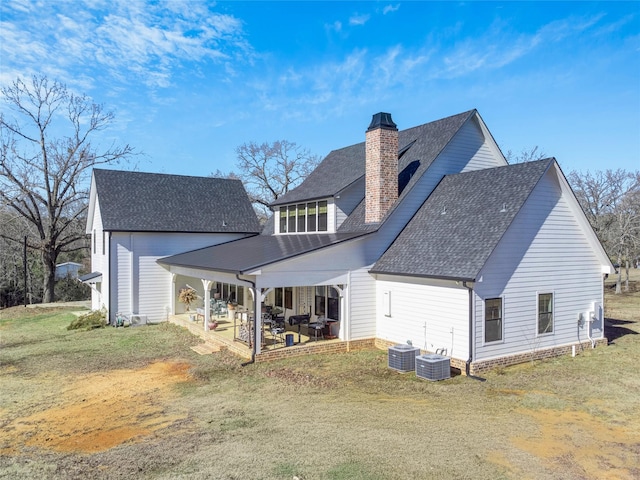 back of house with central AC unit, a patio area, and a yard