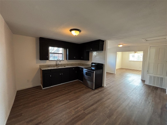 kitchen with electric stove, dark hardwood / wood-style flooring, sink, and a healthy amount of sunlight