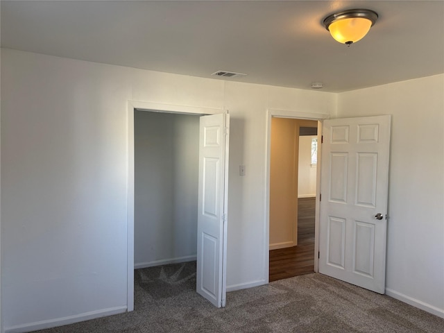 unfurnished bedroom featuring a closet and dark colored carpet