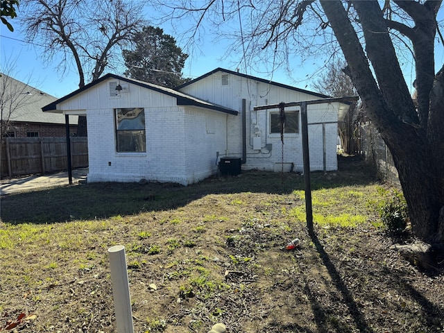 exterior space featuring central air condition unit and a front lawn