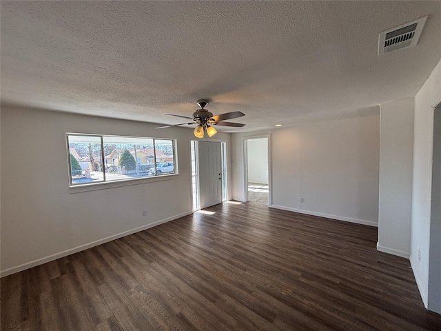 unfurnished room featuring ceiling fan, dark hardwood / wood-style floors, and a textured ceiling