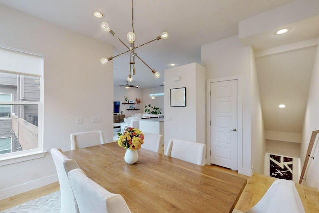 dining area featuring ceiling fan with notable chandelier and light hardwood / wood-style flooring