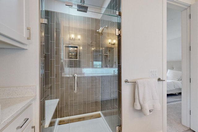 bathroom featuring a shower with door and vanity