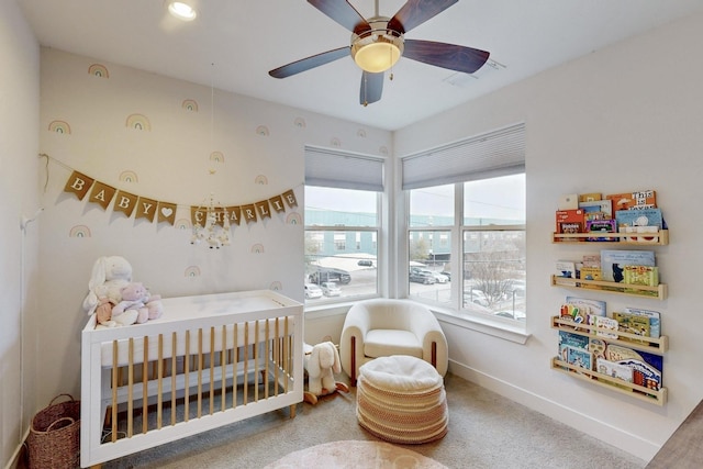 bedroom with ceiling fan and a crib