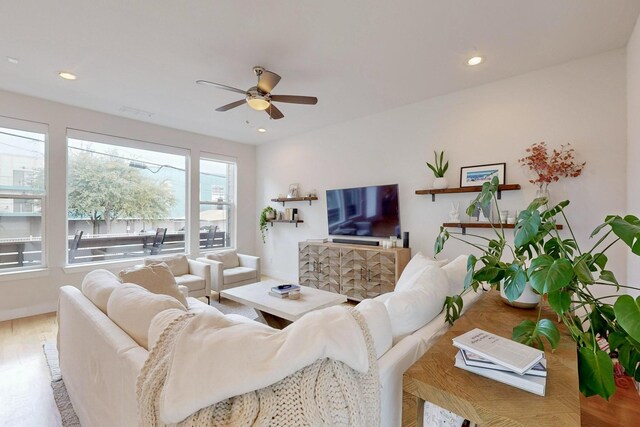 living room featuring ceiling fan, light hardwood / wood-style flooring, and a healthy amount of sunlight