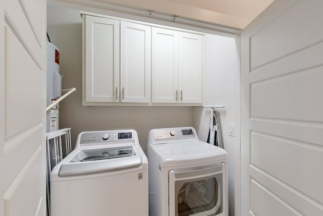 washroom featuring separate washer and dryer and cabinets