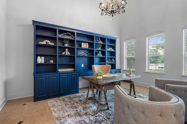 office area featuring light tile patterned floors, baseboards, an inviting chandelier, and a towering ceiling