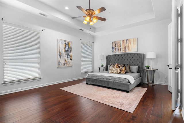 bedroom featuring baseboards, a raised ceiling, and dark wood finished floors