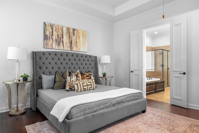 bedroom featuring ensuite bath, crown molding, baseboards, and hardwood / wood-style flooring