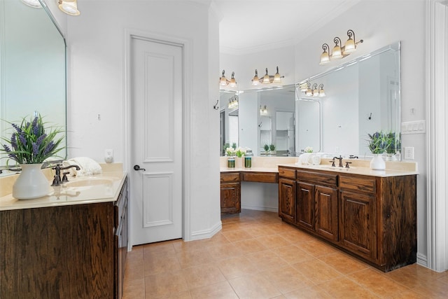 bathroom with tile patterned flooring, ornamental molding, two vanities, and a sink