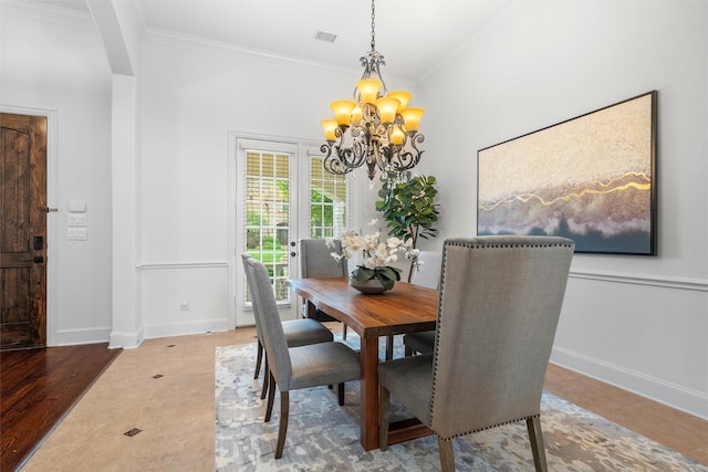 dining room with wood-type flooring, ornamental molding, and an inviting chandelier