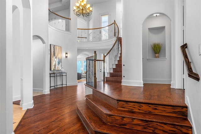 entryway featuring a notable chandelier, stairway, plenty of natural light, and wood finished floors