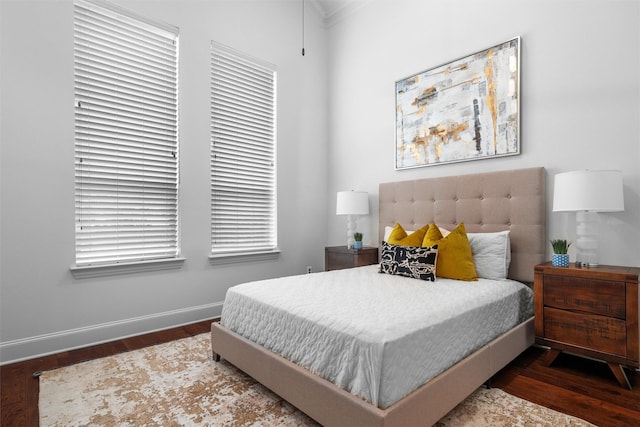 bedroom with dark wood-type flooring and crown molding