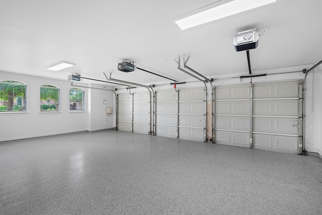 garage with a garage door opener and baseboards