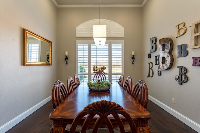 dining room featuring crown molding, dark wood-type flooring, and a towering ceiling