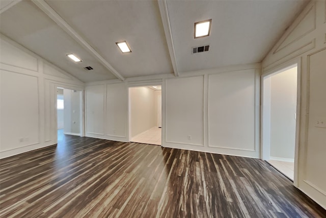 unfurnished room featuring vaulted ceiling with beams and dark wood-type flooring