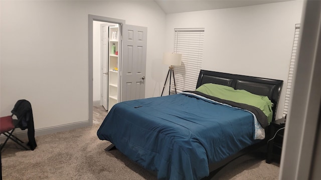 carpeted bedroom with lofted ceiling