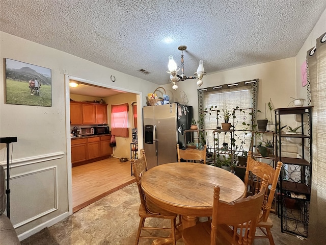 dining space featuring a textured ceiling and a notable chandelier