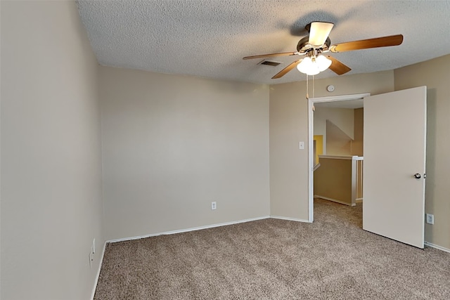 spare room with light carpet, ceiling fan, and a textured ceiling