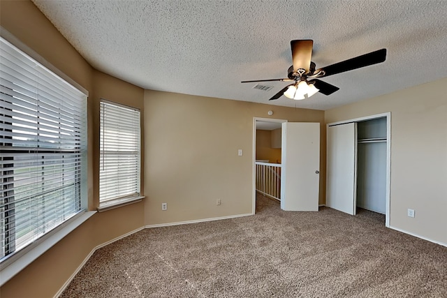 unfurnished bedroom featuring ceiling fan, a closet, carpet, and a textured ceiling