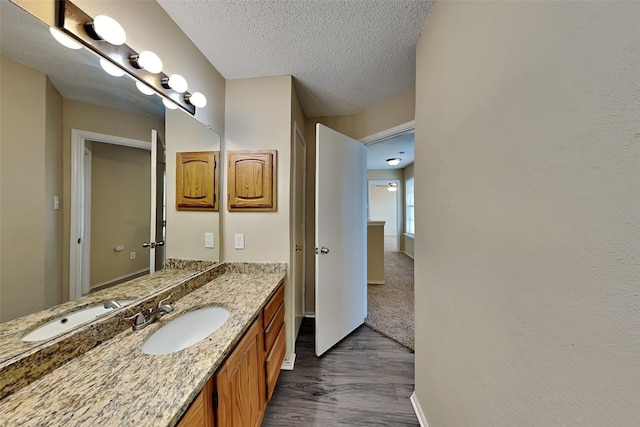 bathroom featuring hardwood / wood-style flooring, a textured ceiling, and vanity