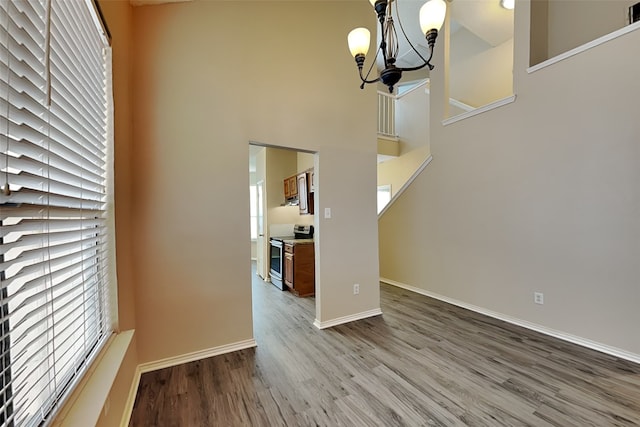 interior space featuring a high ceiling, a chandelier, and wood-type flooring