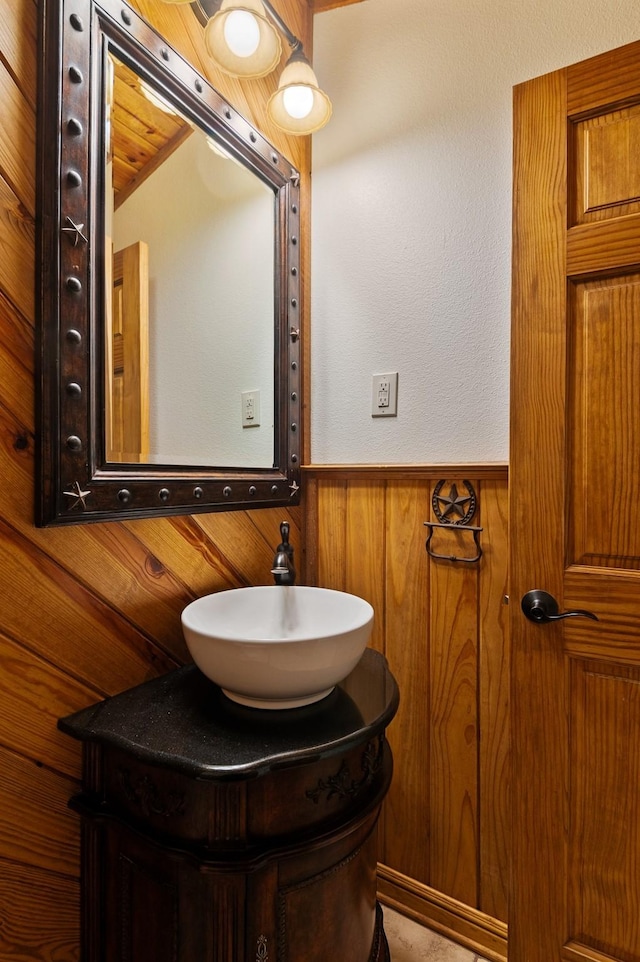 bathroom with vanity and wood walls