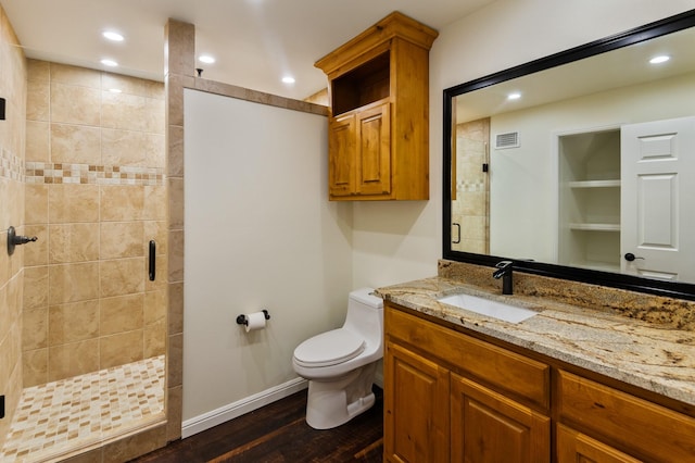 bathroom featuring toilet, wood-type flooring, vanity, and walk in shower