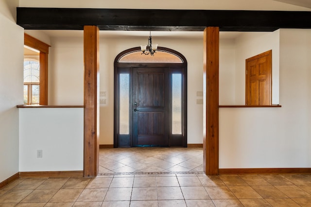 tiled foyer with beamed ceiling and a notable chandelier